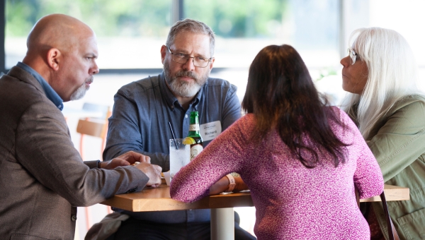 A group of men and women have a discussion during an Executive Advantage networking event.
