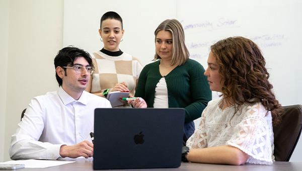 Maddie Curtis, Edgardo Diaz Velazquez, Hanna Theile, and Belen Torres work together at a table.