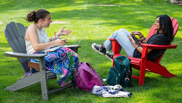 Two happy students study outdoors at CMU.